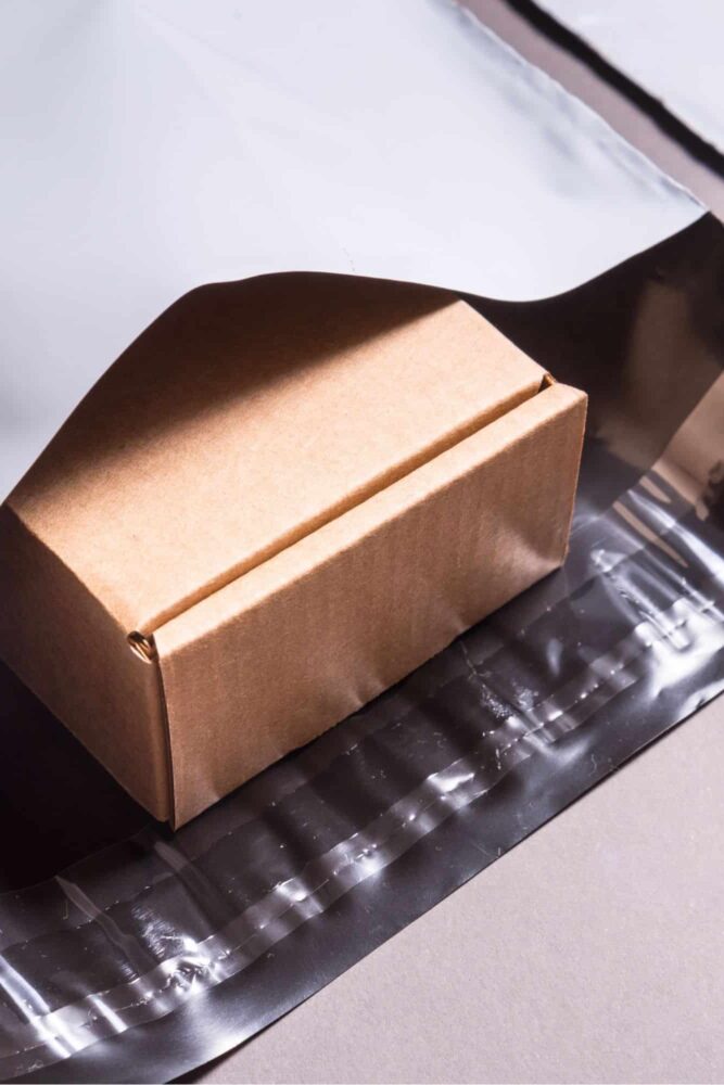 Cardboard box in a white mailing bag